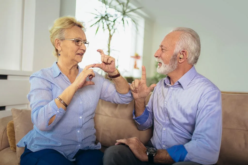 Eine Mitarbeiterin und ein Kind sitzen auf dem Sofa und unterhalten sich